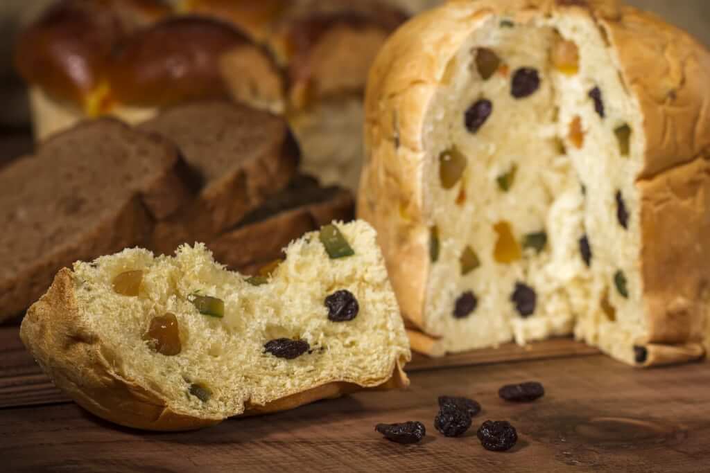 Panettone with a slice cut out, showing the raisins and other dried fruit