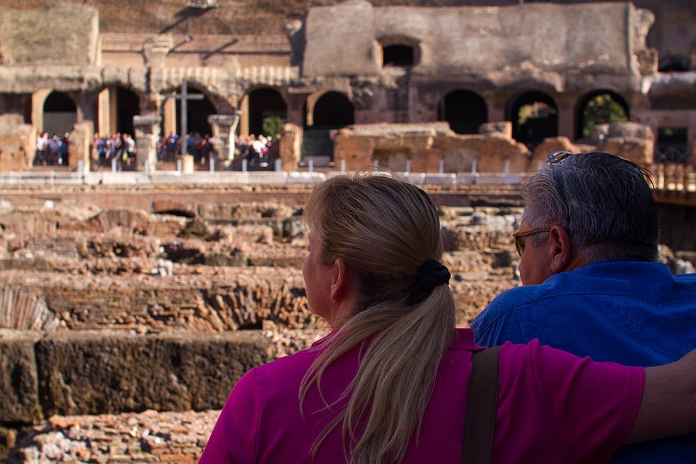 A couple takes in the view inside the Colosseum with a Walks of Italy Tour.
