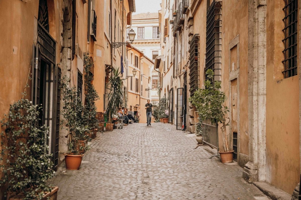 Man strolling down the Trastevere neighborhood of Rome in the fall