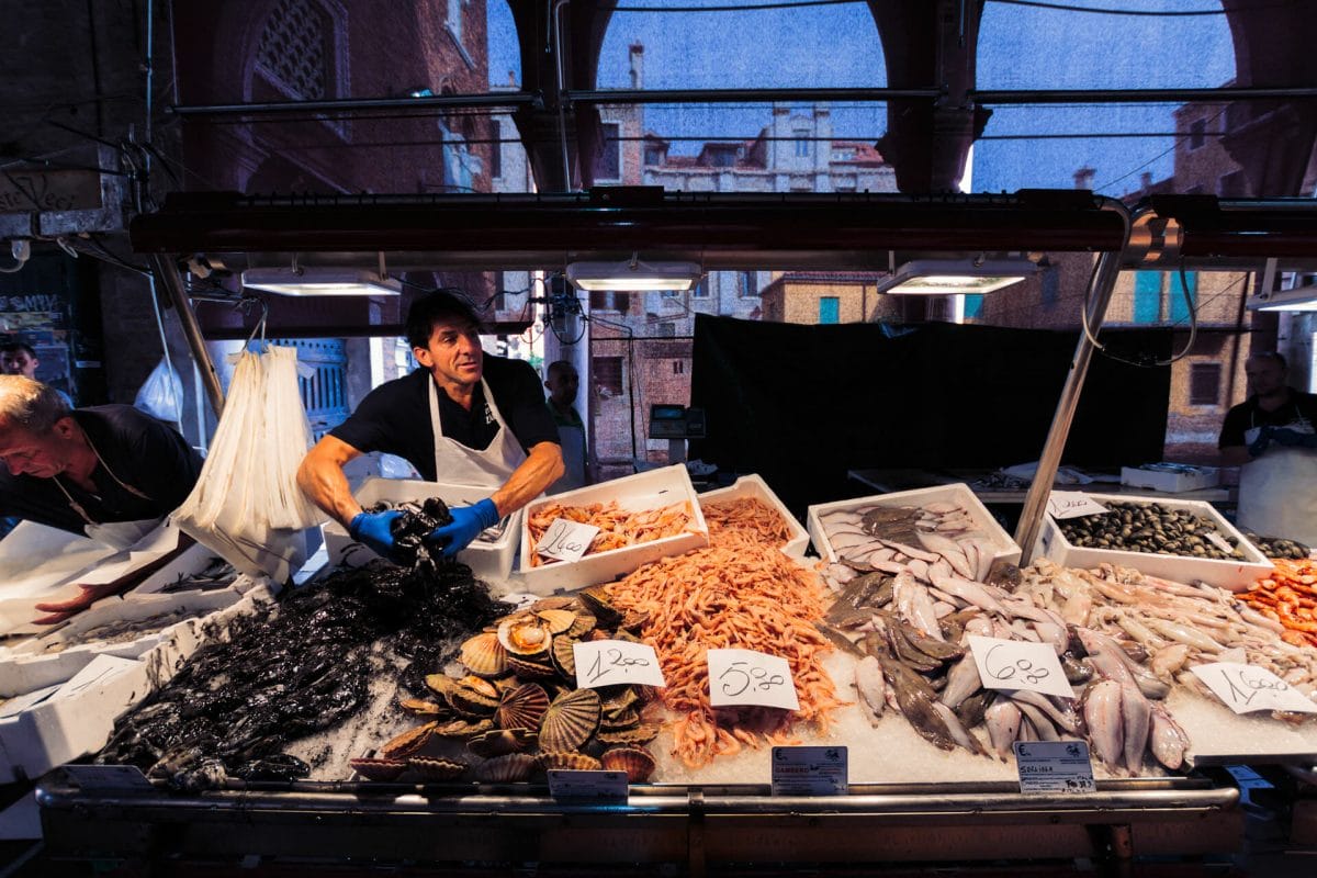 Fish vendor at a market in Venice with many different types of seafood and fish