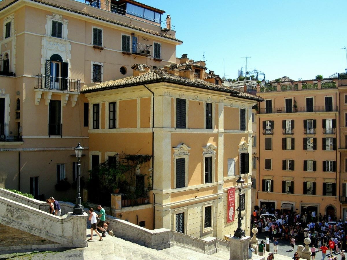 The outside of buildings in Rome with people walking in the background