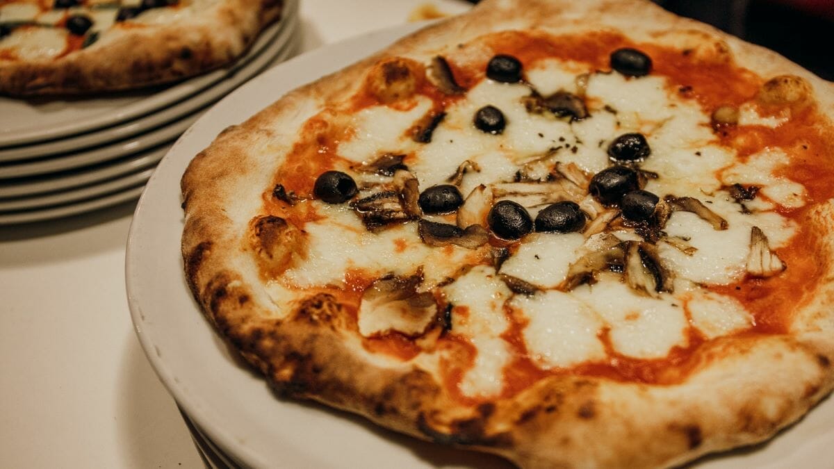Pizza topped with olives and mushrooms