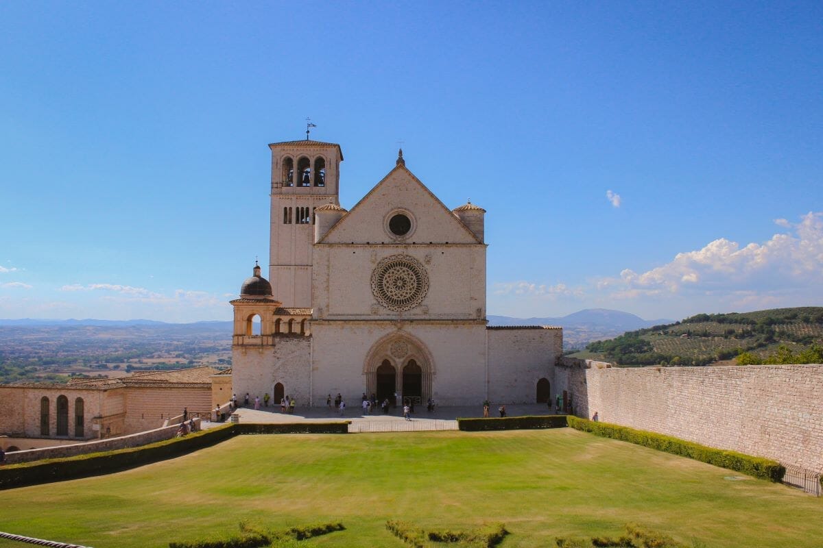 A white chuch on a hill overlooking a city in Italy on a sunny day
