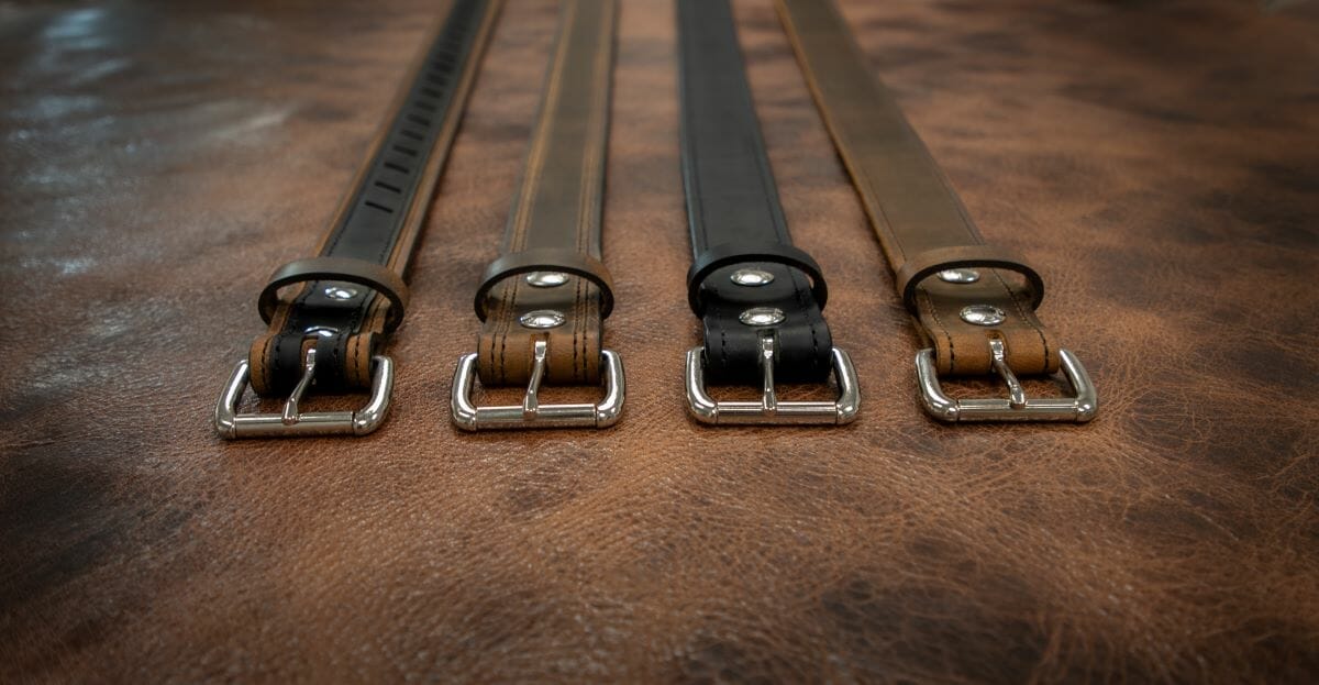 Four leather belts laid on a table